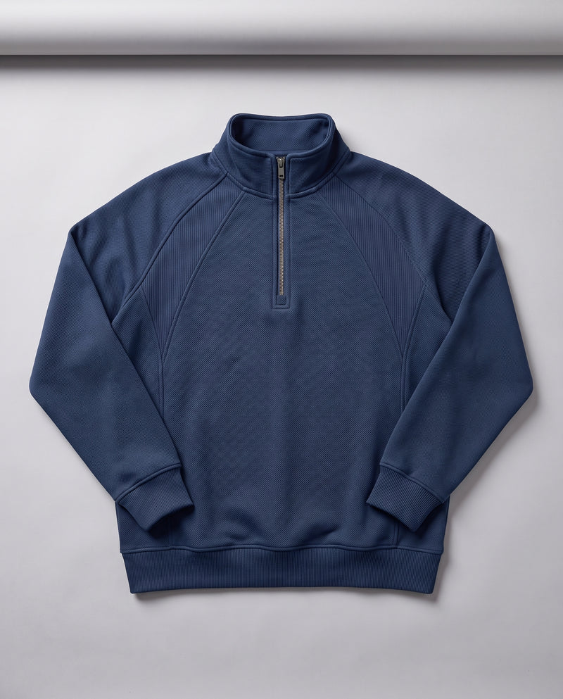 Sweat bleu marine à demi-zip présenté à plat, entièrement déplié, montrant le col montant, la fermeture éclair et les bords côtelés.