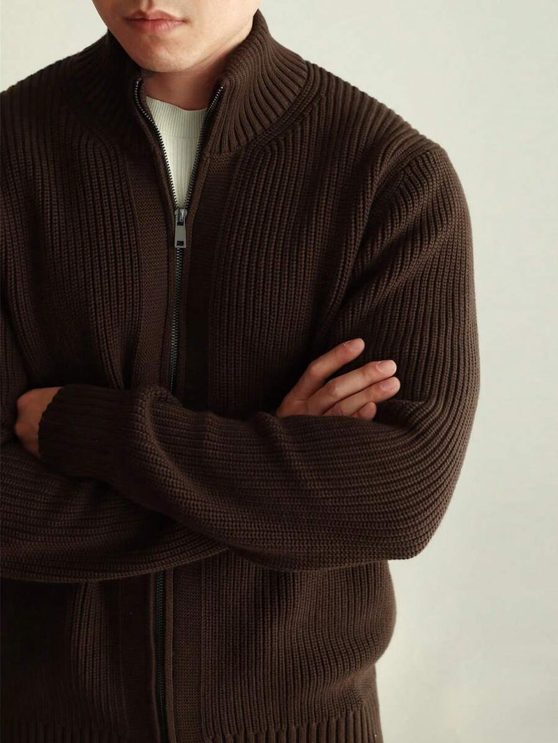 Cardigan zippé en maille côtelée marron à col montant, porté les bras croisés