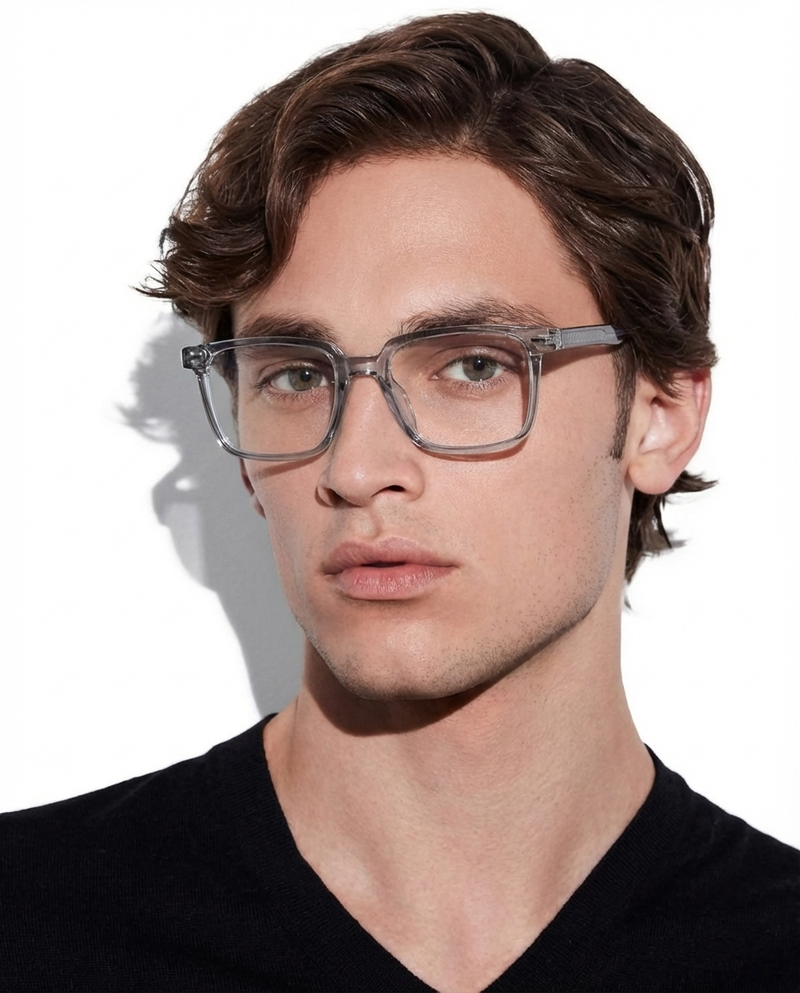 Homme portant des lunettes à monture carrée gris translucide à verres transparents, vue de face