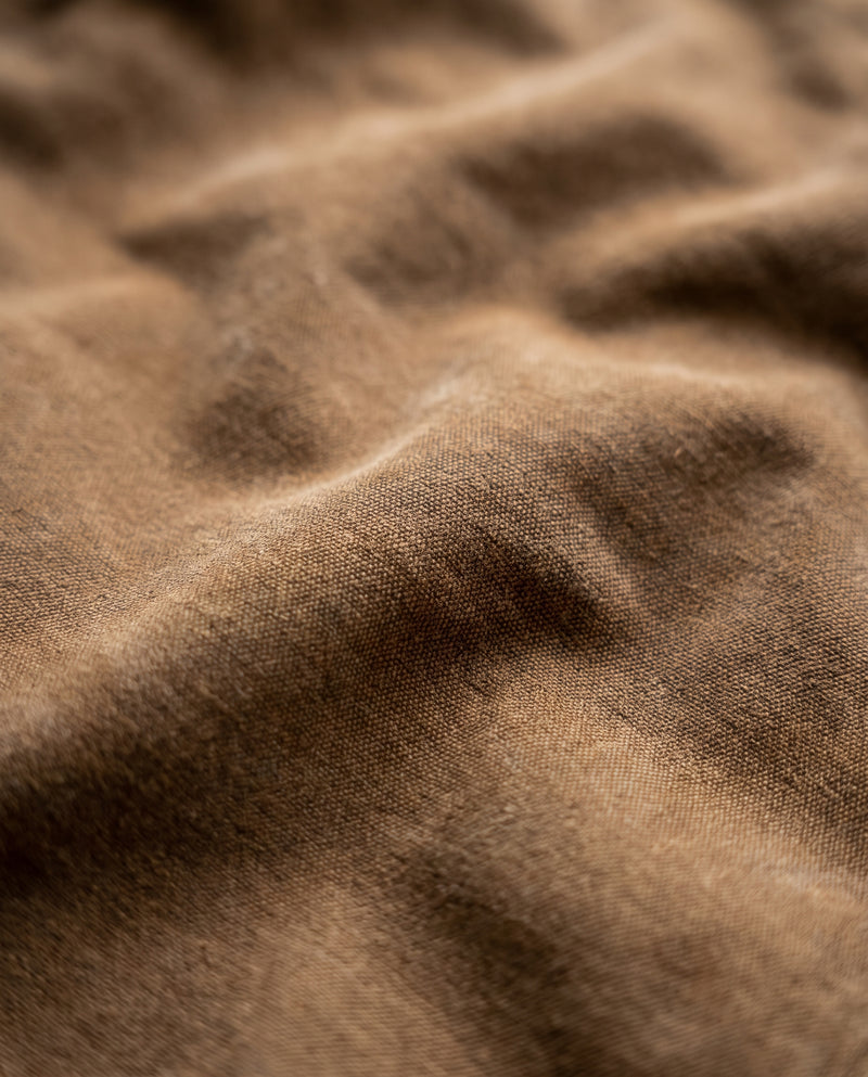 Gros plan sur le tissu marron de la veste Drake, surface mate légèrement délavée.