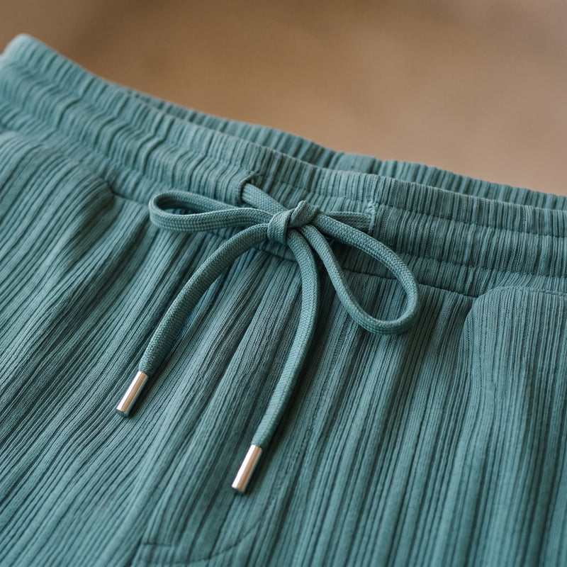 Gros plan sur la taille à cordon de serrage du short, cordons à embouts métalliques