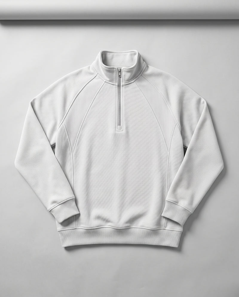 Sweat blanc à demi-zip présenté à plat, entièrement déplié, avec col montant et fermeture éclair.