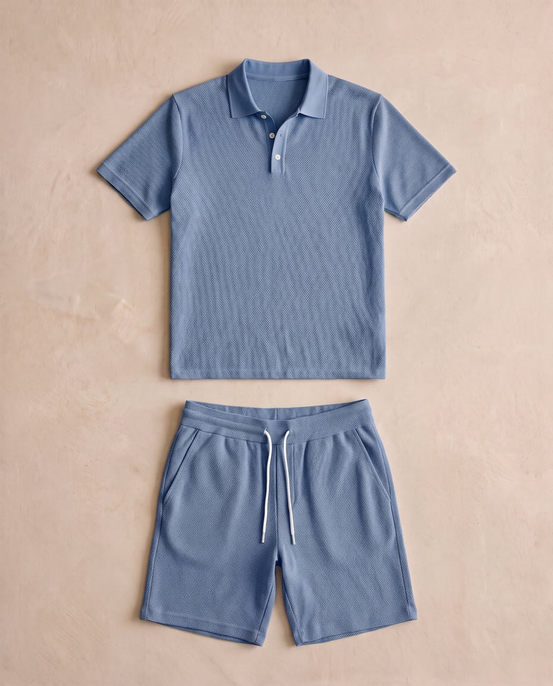 Ensemble polo et short en maille texturée bleu acier, posé à plat