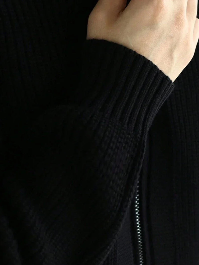 Gros plan sur le poignet côtelé et la couture latérale du cardigan noir
