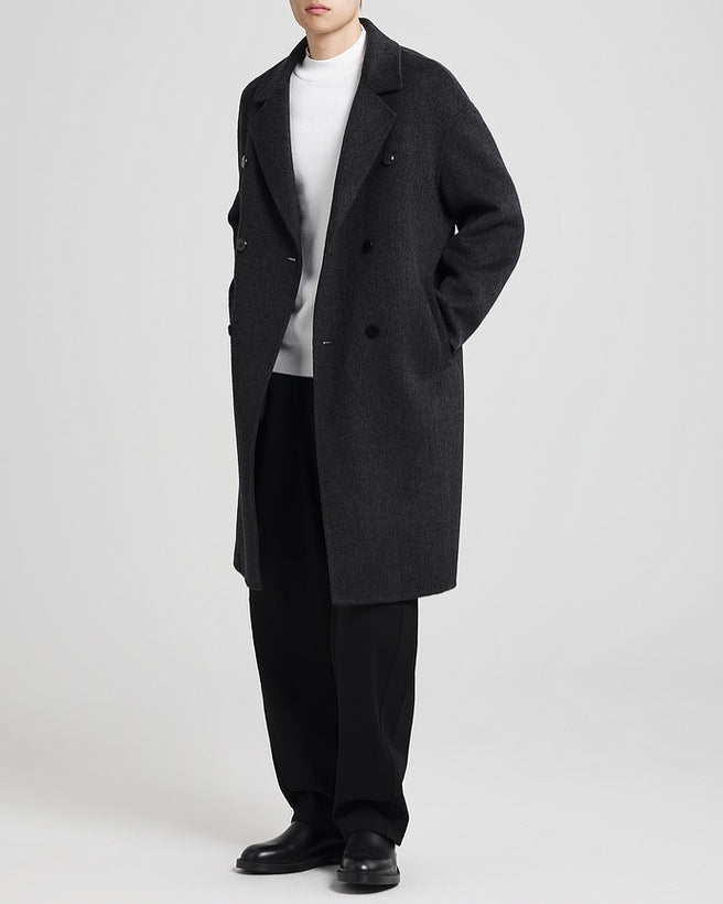 Manteau noir porté ouvert, les mains dans les poches, vue de trois quarts