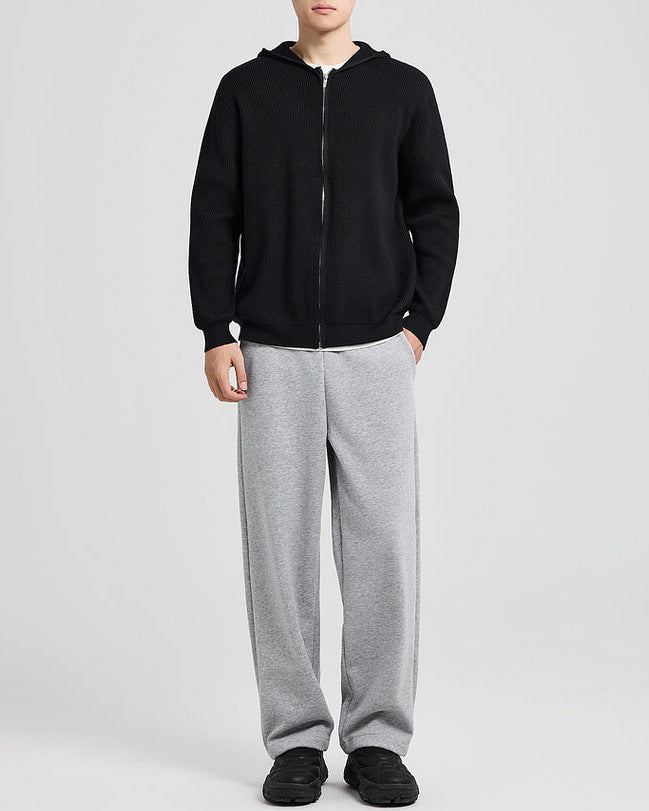 Cardigan en maille à capuche noir porté avec un pantalon gris, vue de face en pied