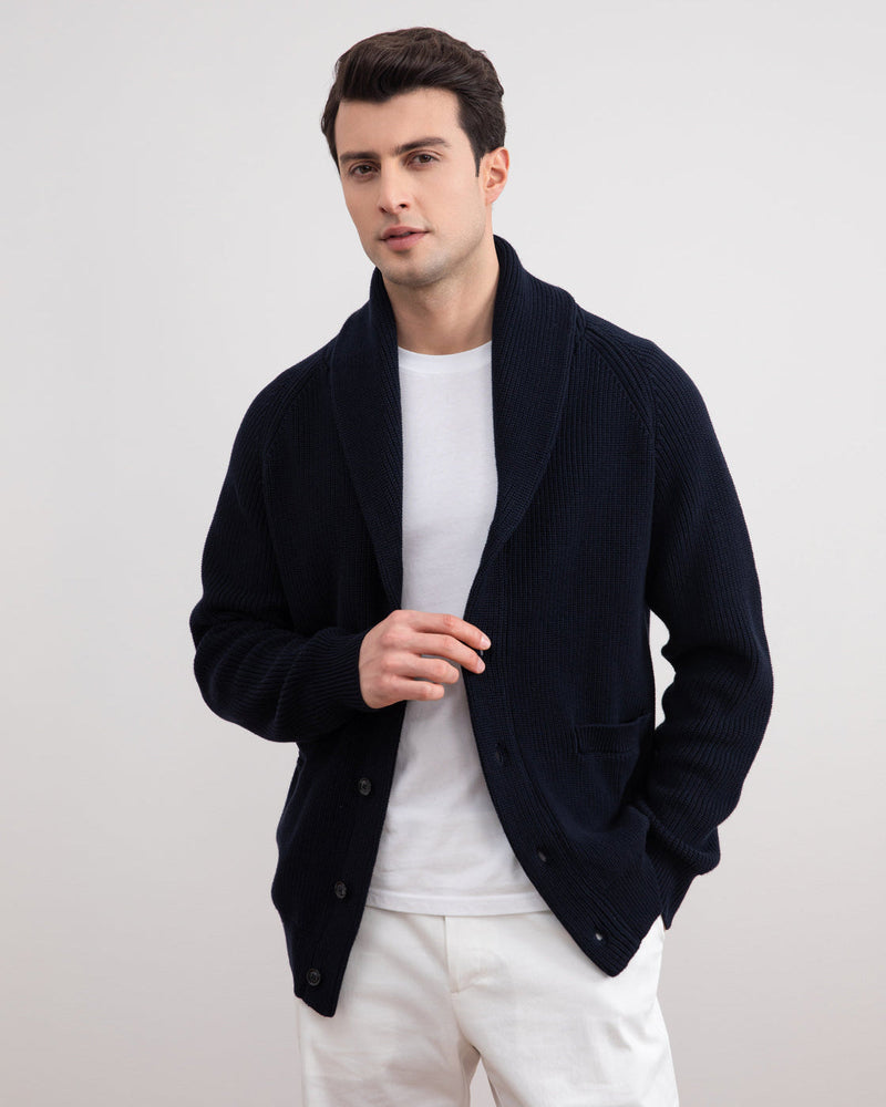 Cardigan bleu marine à col châle porté ouvert sur un t-shirt blanc et un pantalon blanc
