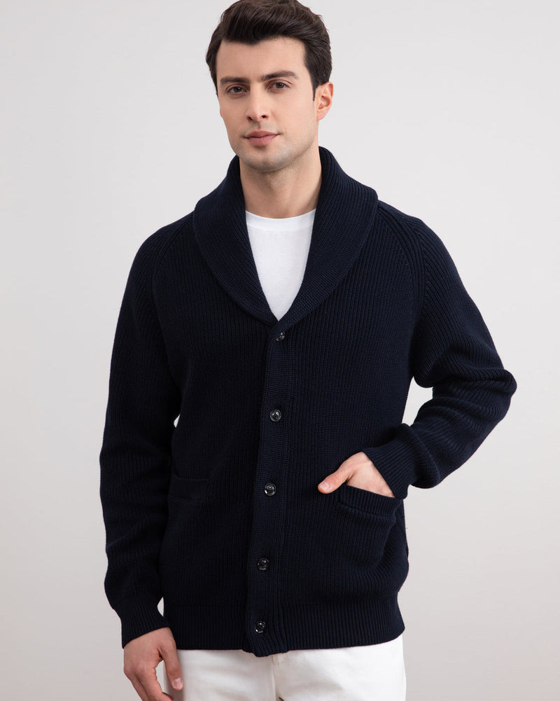 Navy ribbed shawl-collar cardigan worn buttoned with a hand in the pocket