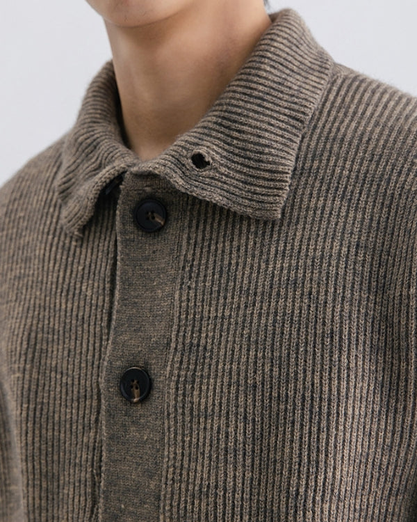 Gros plan sur le col et les boutons foncés du cardigan marron