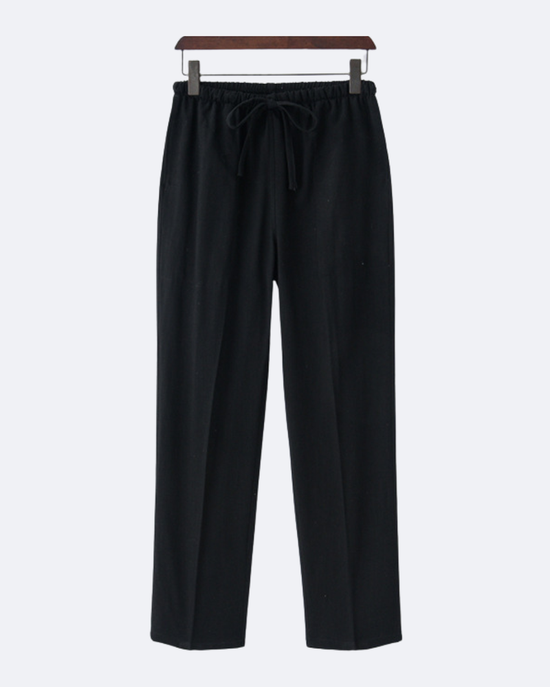 Pantalon noir à cordon de serrage sur un cintre en bois, vue de face
