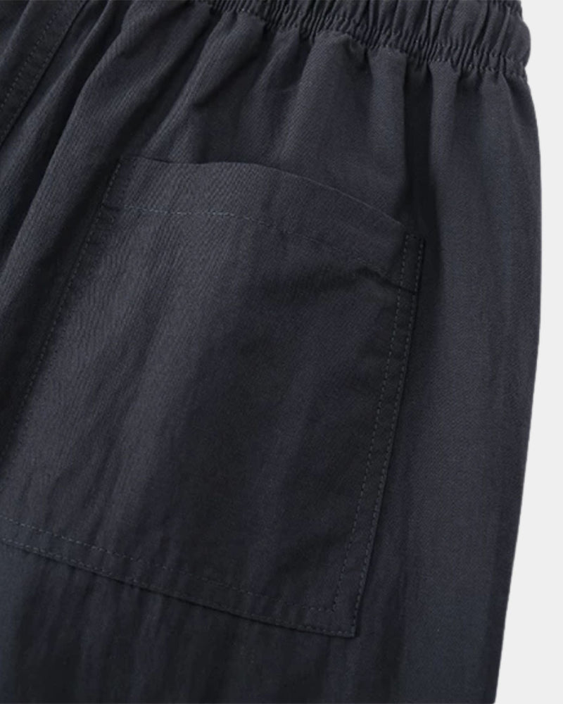 Gros plan sur la poche plaquée et le tissage texturé du pantalon bleu marine foncé