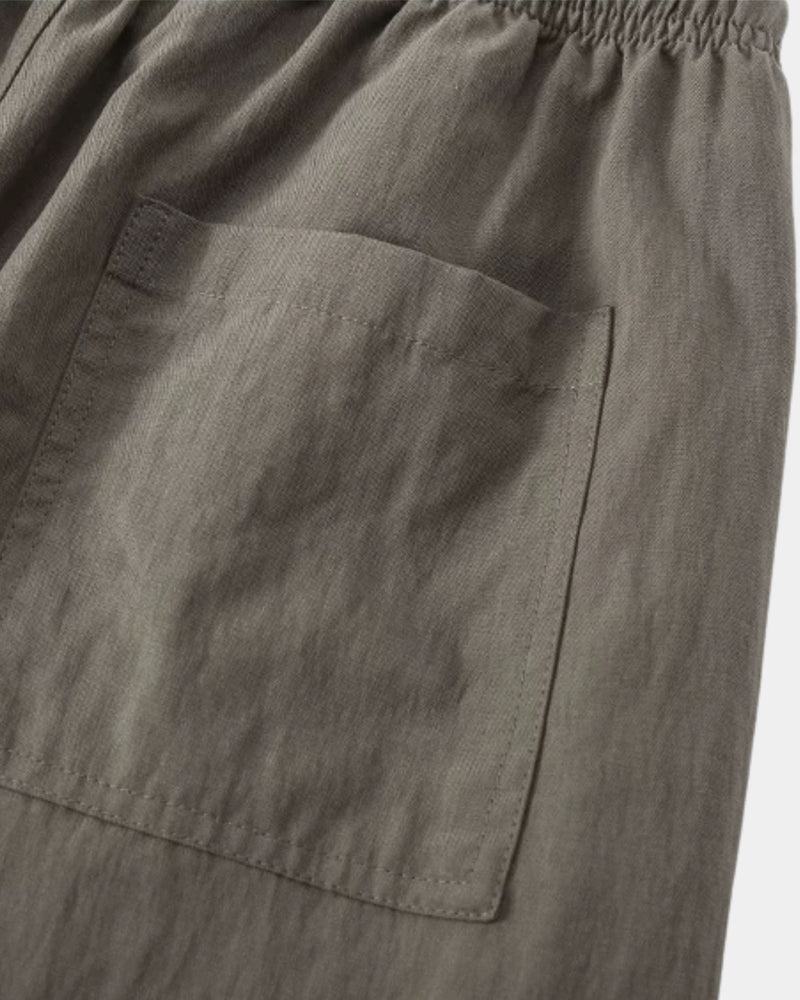Gros plan sur la poche plaquée et le tissage texturé du pantalon gris olive