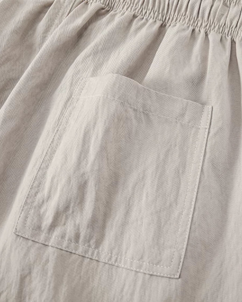 Gros plan sur la poche plaquée et le tissage texturé du pantalon crème