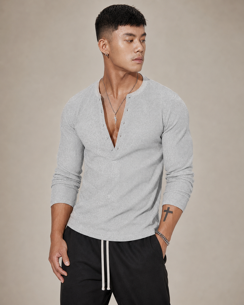Pull Kade en maille côtelée gris porté par un mannequin, vue trois quarts, texture côtelée visible sur la manche et le buste.