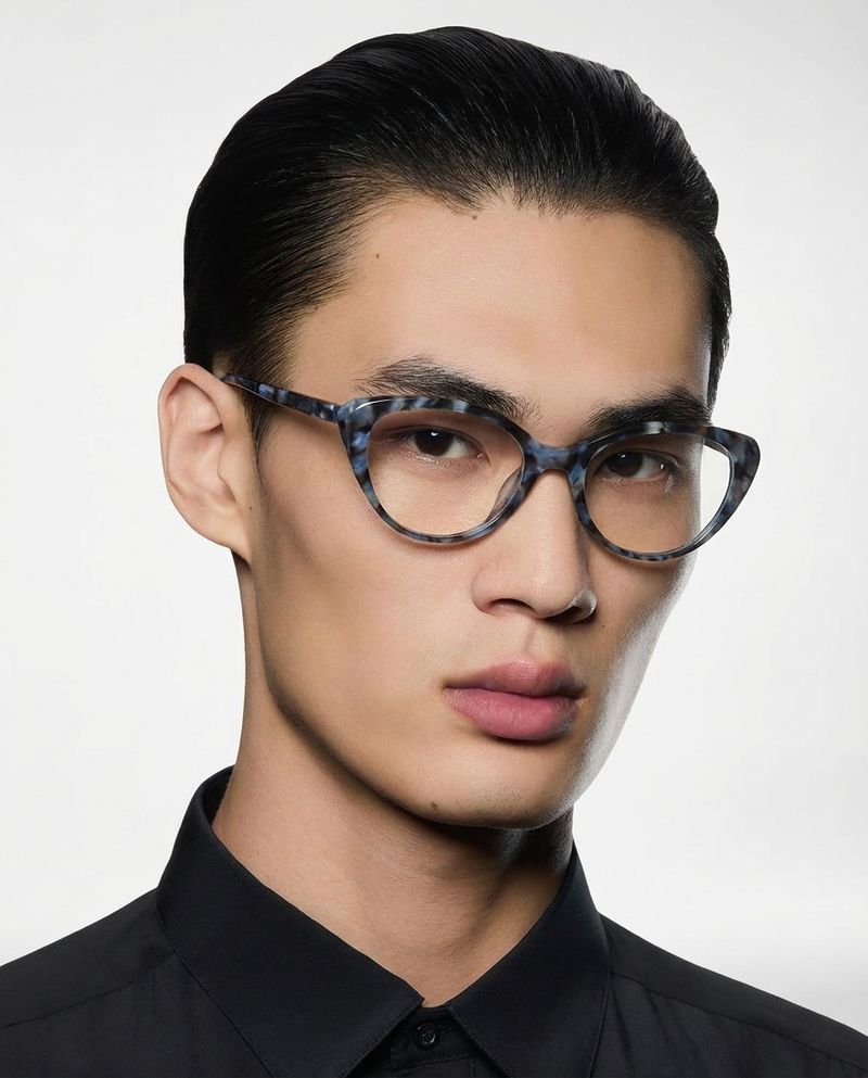 Homme portant des lunettes à monture œil-de-chat bleue à motifs, verres transparents, vue de trois quarts