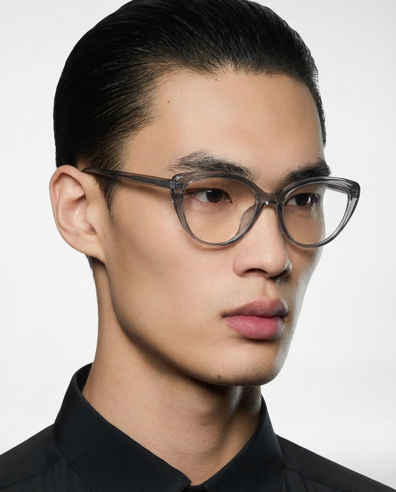 Homme portant des lunettes à monture œil-de-chat gris translucide à verres transparents, vue de trois quarts