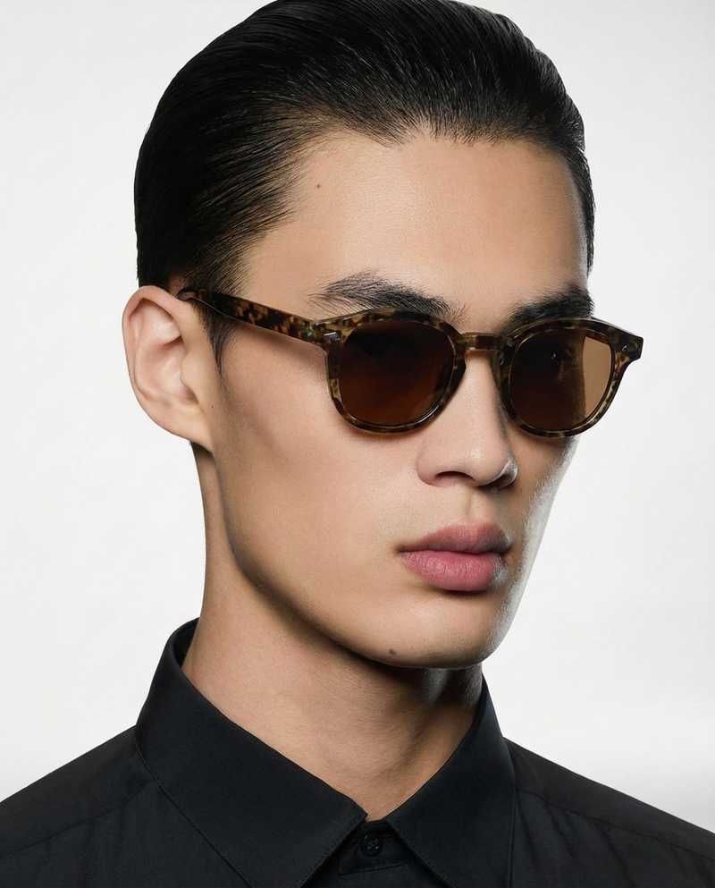 Homme portant des lunettes de soleil à monture ronde écaille à verres marron, vue de face