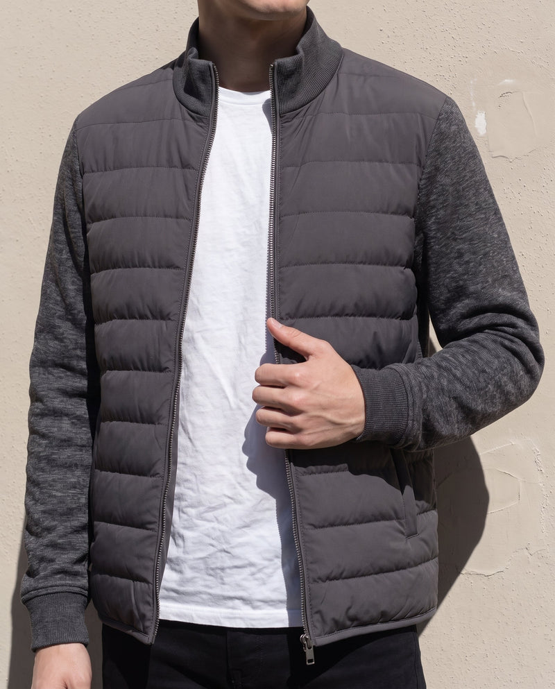 Bellardi Hybrid Puffer Jacket in Dark Grey, worn open over a white t-shirt, showing the ribbed knit collar and centre-front zip.