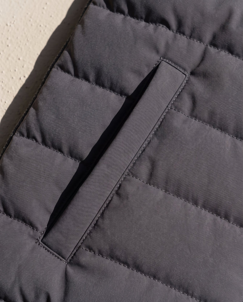 Close-up of a hip welt pocket on the Bellardi Hybrid Puffer Jacket in Dark Grey, showing the quilted shell fabric and stitching.