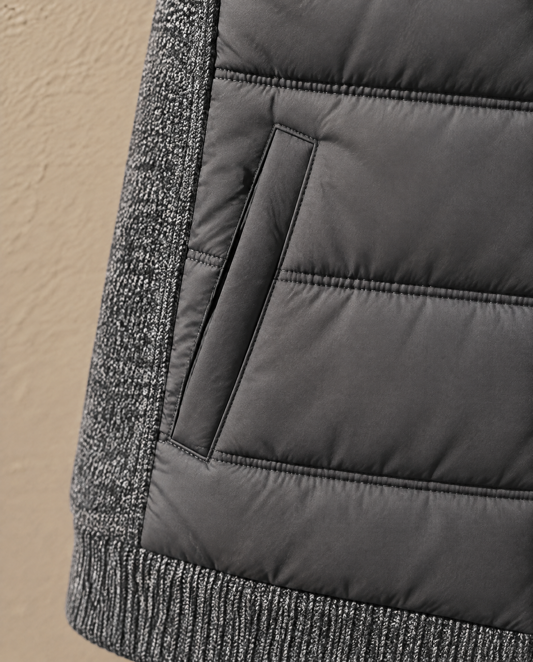 Close-up of the angled hip welt pocket on the Bellardi Hybrid Puffer Jacket in Dark Grey