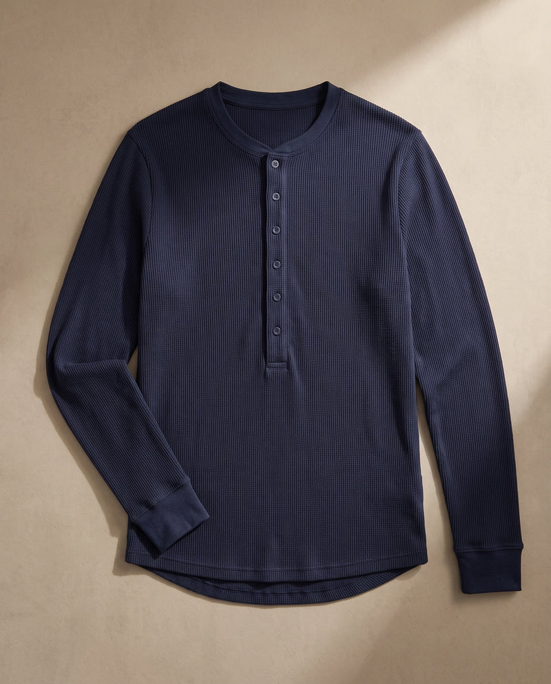 Pull Kade en maille côtelée bleu marine à plat, déplié, montrant l'encolure ronde côtelée, la demi-patte de boutonnage et l'ourlet arrondi.