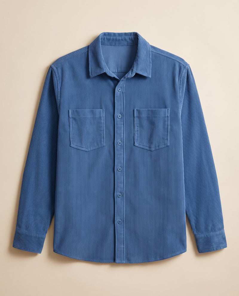 Peacock blue corduroy overshirt laid flat on a chalk background, front view