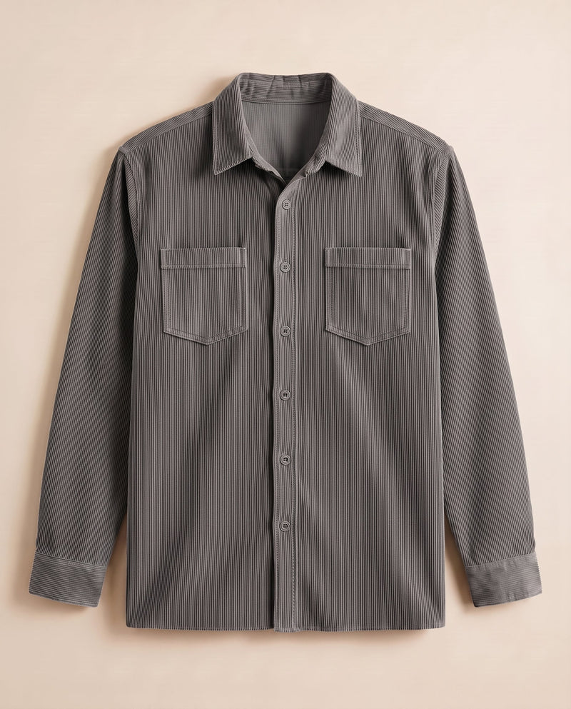 Grey corduroy overshirt laid flat on a chalk background, front view