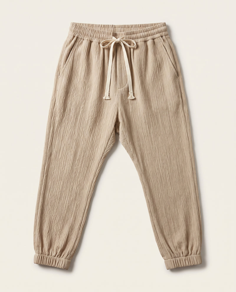Pantalon confort beige à plat, vue de face, tissage froissé et cordon de serrage écru à la taille.