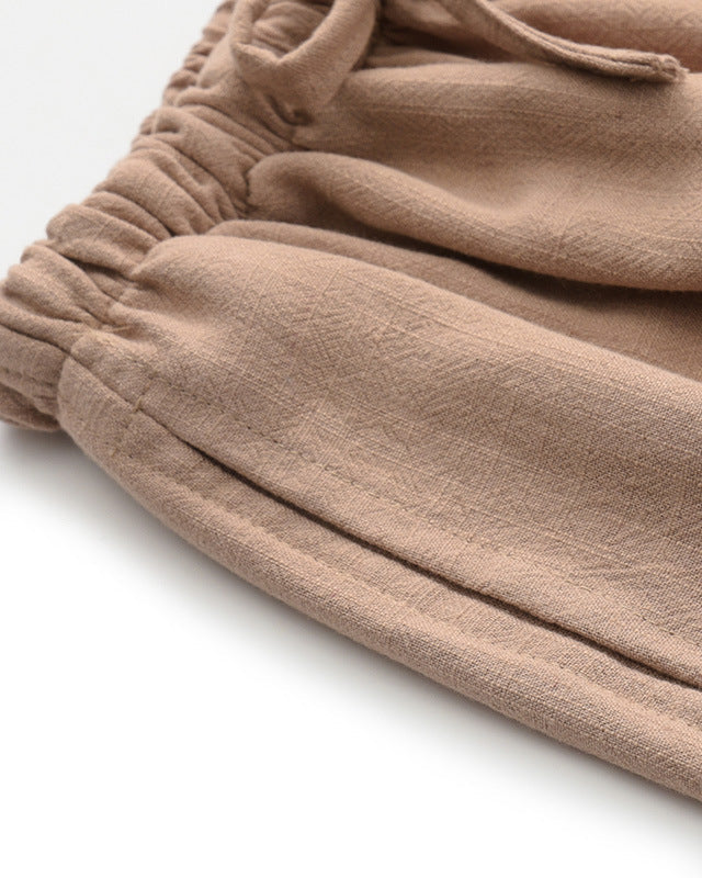 Gros plan sur l'ourlet froncé et la couture latérale du pantalon fauve