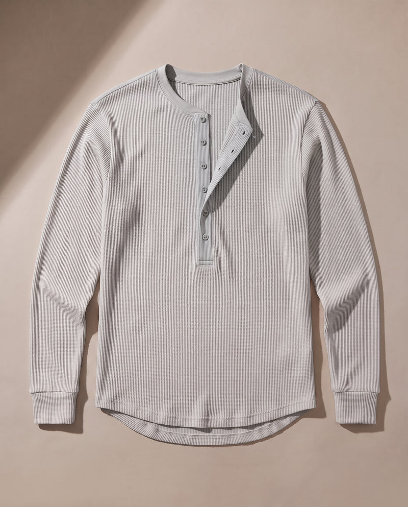 Pull Kade en maille côtelée gris à plat, déplié, montrant l'encolure ronde côtelée, la demi-patte de boutonnage et l'ourlet arrondi.
