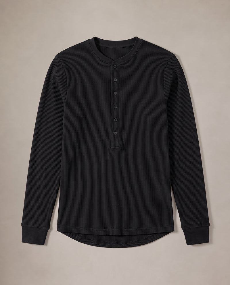 Pull Kade en maille côtelée noir à plat, déplié, montrant l'encolure ronde côtelée, la demi-patte de boutonnage et l'ourlet arrondi.