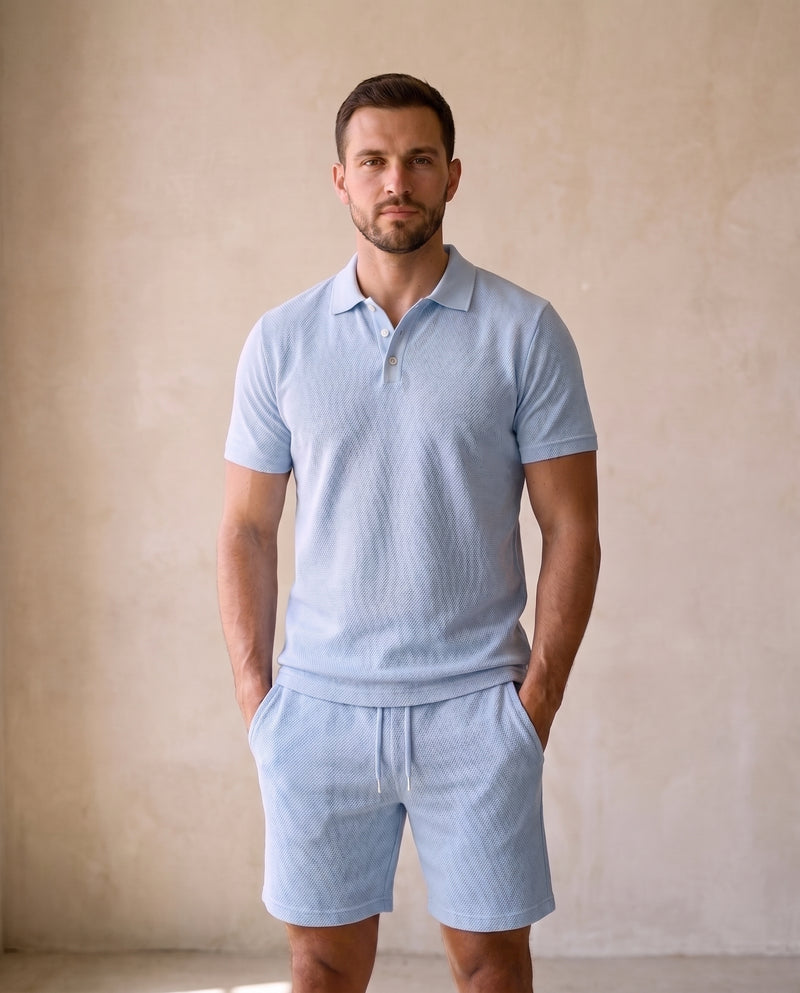 Homme portant un polo en maille texturée bleu clair et le short assorti, vue de face