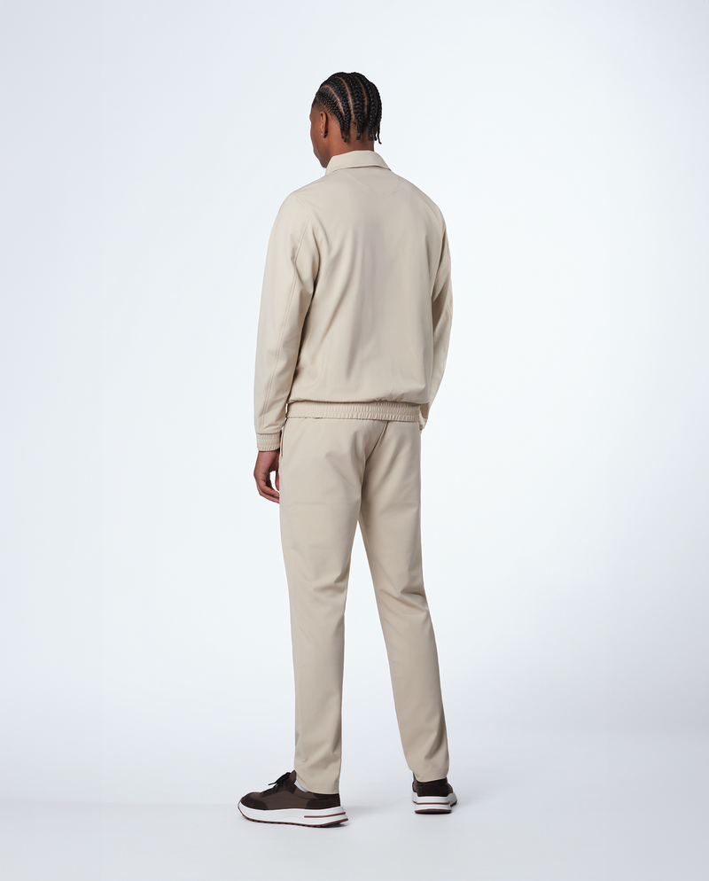 Homme portant un pantalon beige avec la veste zippée assortie, vue de dos en pied
