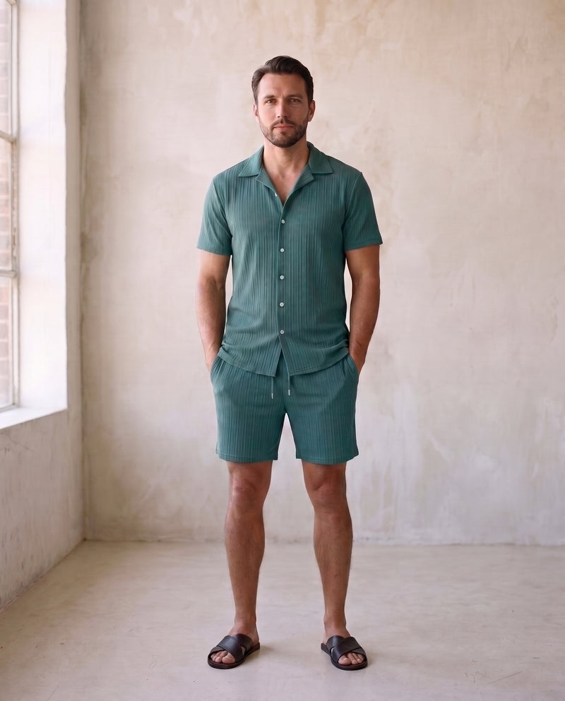 Homme portant une chemise à manches courtes côtelée verte et le short assorti à cordon de serrage, avec des sandales en cuir foncé, en pied